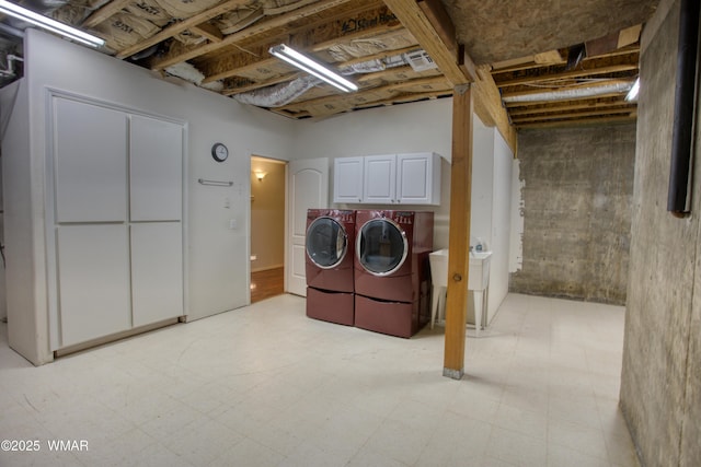 laundry room featuring light floors, washing machine and clothes dryer, and cabinet space