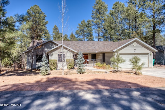 ranch-style home featuring driveway, a garage, a porch, and roof with shingles