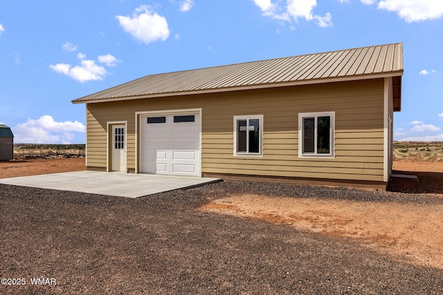 2740 E Walnut Dr, Taylor, AZ 85939 - rear view of house with metal roof, an outdoor structure, dirt driveway, and a garage