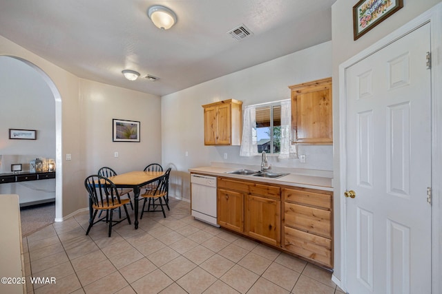 2740 E Walnut Dr, Taylor, AZ 85939 - kitchen with white dishwasher, a sink, light countertops, arched walkways, and light tile patterned floors