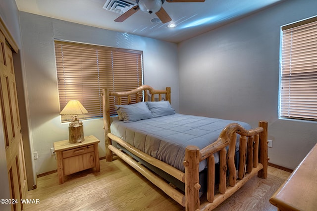 bedroom featuring light wood-style floors, visible vents, baseboards, and a ceiling fan