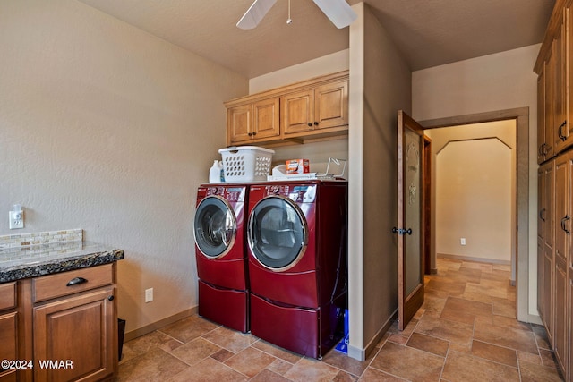 washroom featuring cabinet space, baseboards, ceiling fan, stone finish flooring, and washing machine and dryer