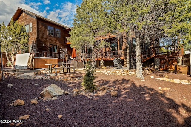 rear view of house with a jacuzzi and a deck