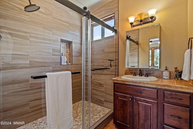 full bathroom featuring a stall shower and vanity