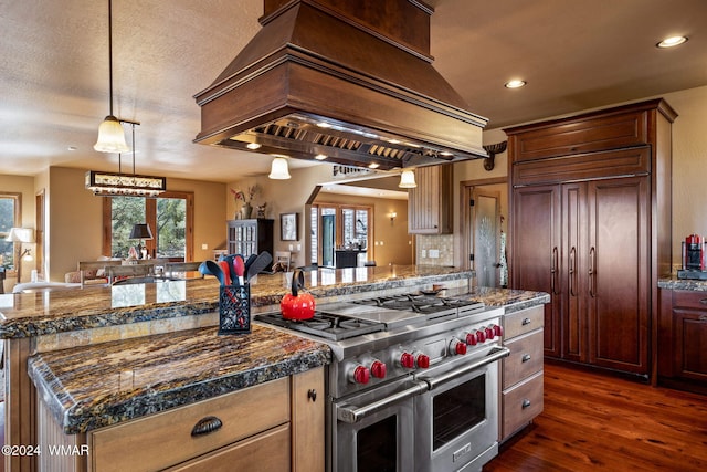kitchen featuring a center island, high end appliances, custom range hood, hanging light fixtures, and dark wood-type flooring