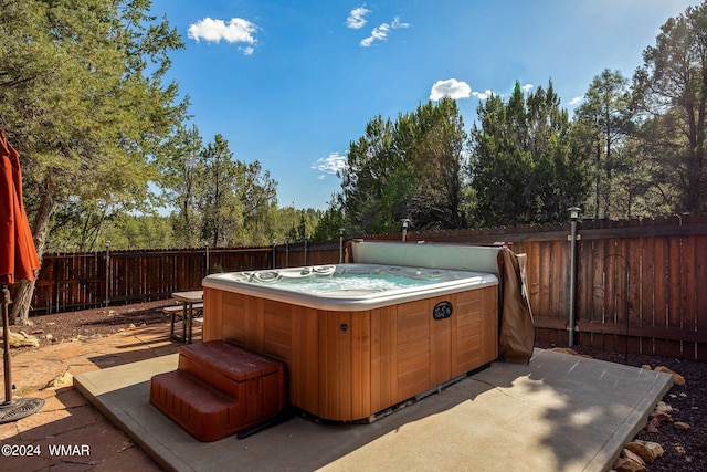 view of patio with a fenced backyard and a hot tub