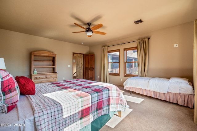 carpeted bedroom with visible vents and ceiling fan
