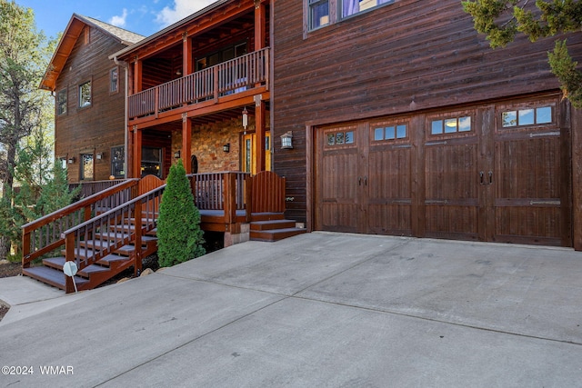 view of front facade featuring a garage, driveway, and a balcony