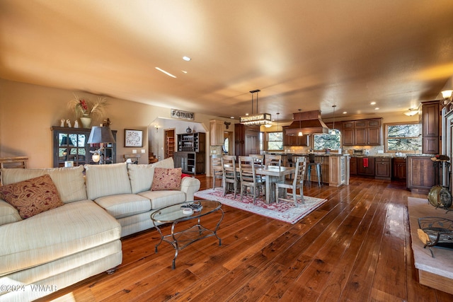 living room with dark wood-style floors, ornate columns, and recessed lighting