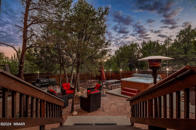 wooden deck featuring a patio area, a fenced backyard, a hot tub, and an outdoor hangout area
