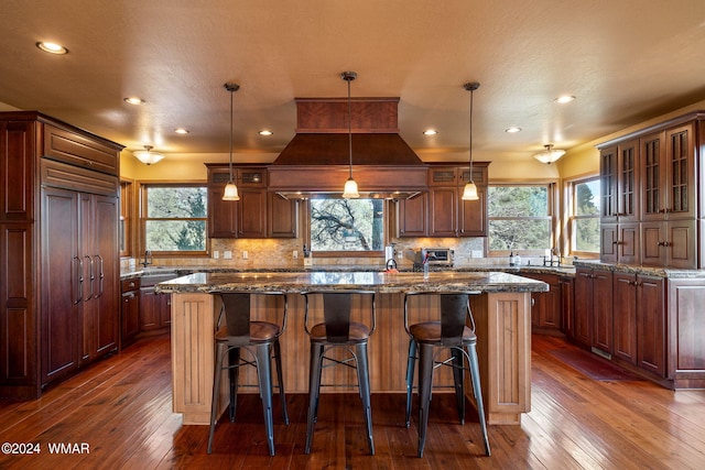kitchen with hanging light fixtures, a kitchen island, and glass insert cabinets