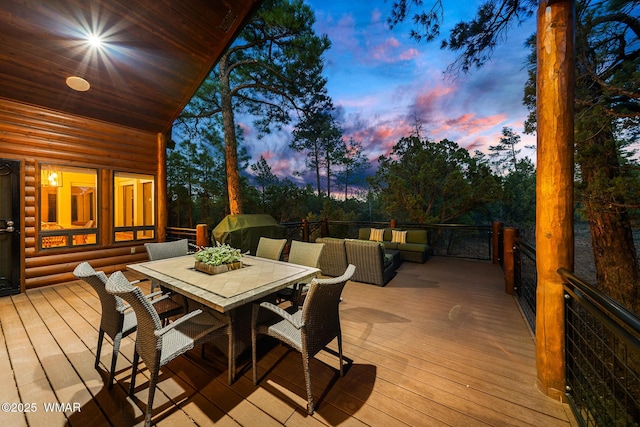 deck at dusk with outdoor dining space