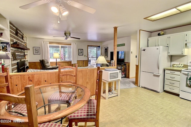 2413 Lupine Cir, Pinetop, AZ 85935 - dining space with a ceiling fan, a wainscoted wall, wooden walls, and light floors