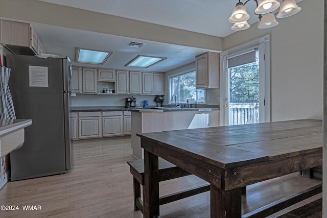 dining space featuring light wood finished floors, visible vents, and a chandelier