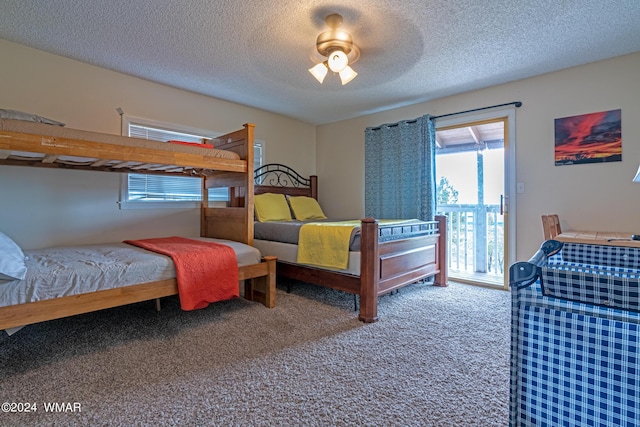 bedroom featuring a textured ceiling, access to outside, multiple windows, and carpet