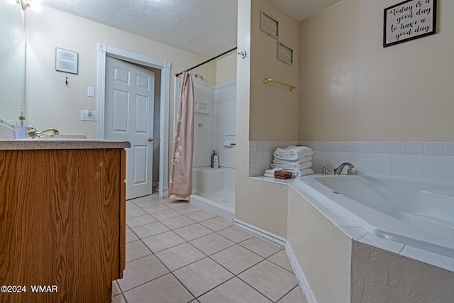 bathroom featuring a textured ceiling, a garden tub, vanity, a shower stall, and tile patterned floors