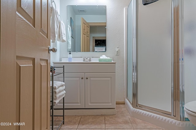 bathroom with a stall shower, visible vents, toilet, tile patterned floors, and vanity