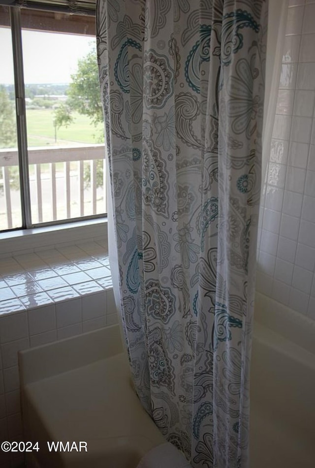 bathroom with shower / bath combo with shower curtain