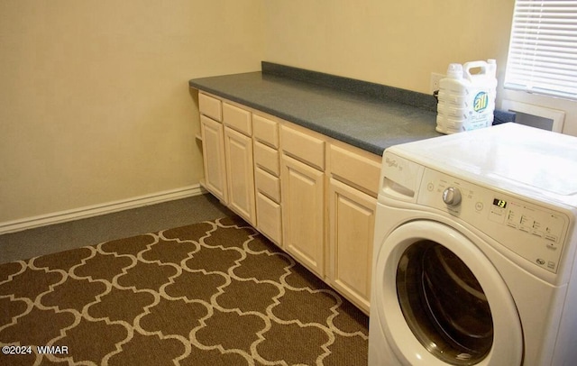 washroom featuring cabinet space, baseboards, and washer / clothes dryer