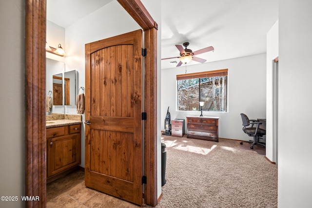 hall featuring baseboards and light carpet