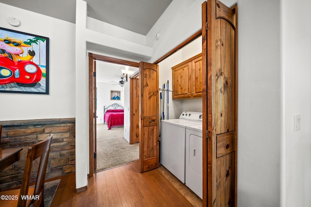 laundry area featuring cabinet space, washer and dryer, a ceiling fan, and wood finished floors