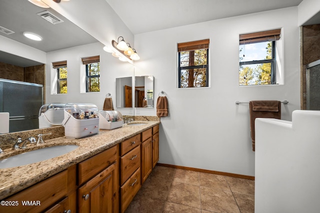 full bathroom featuring a shower stall, baseboards, visible vents, and a sink