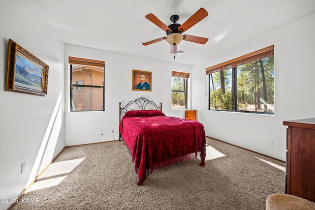 carpeted bedroom with visible vents, baseboards, and a ceiling fan