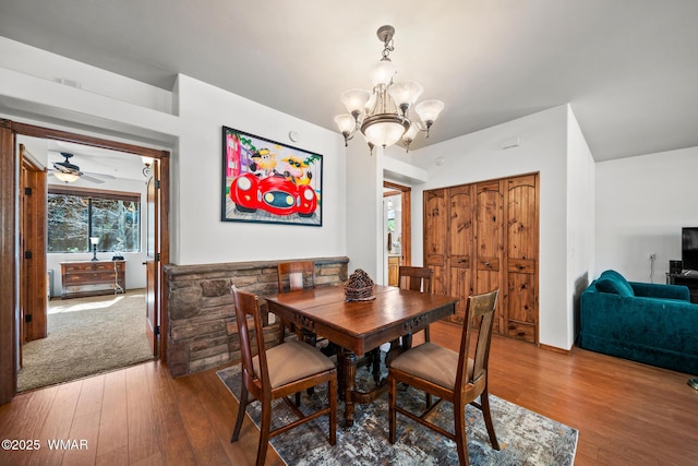 dining space featuring wood-type flooring and a notable chandelier