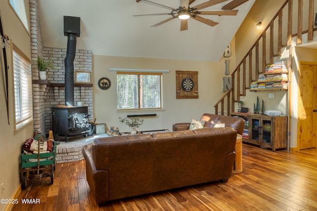 6970 Palomino Dr, Pinetop, AZ 85935 - living area featuring ceiling fan, a wood stove, stairs, wood finished floors, and lofted ceiling