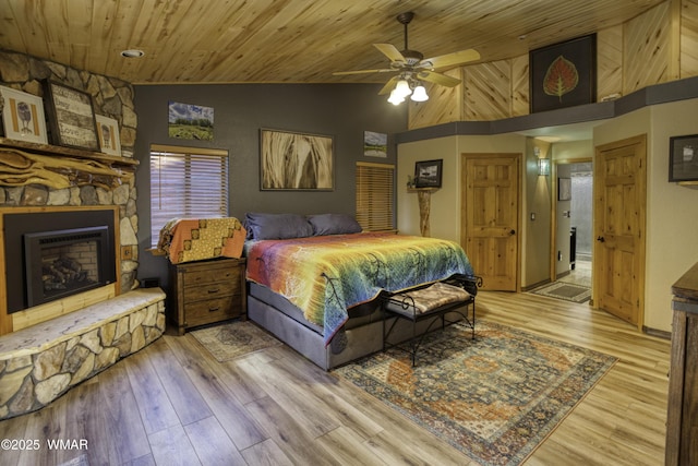 2100 E Ridge Dr, Pinetop, AZ 85935 - bedroom featuring high vaulted ceiling, a stone fireplace, light wood-style flooring, wood ceiling, and a ceiling fan