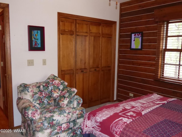 bedroom with wooden walls and a closet