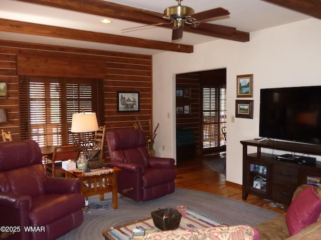 living area featuring ceiling fan, recessed lighting, baseboards, wood finished floors, and beamed ceiling