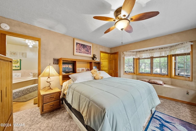 bedroom with ceiling fan, a textured ceiling, wood finished floors, and ensuite bathroom