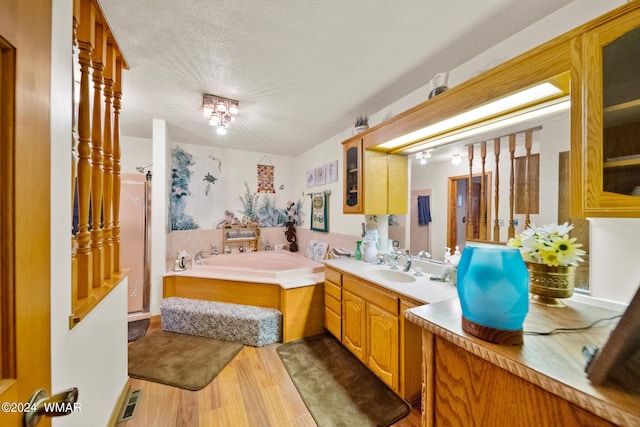 full bath with visible vents, a stall shower, wood finished floors, a bath, and vanity