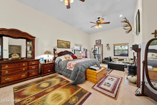 carpeted bedroom with multiple windows, a high ceiling, and ceiling fan