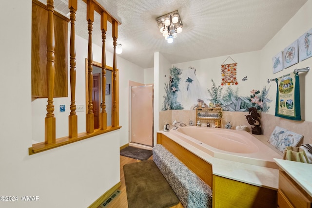 full bathroom with wood finished floors, visible vents, a shower stall, a textured ceiling, and a garden tub