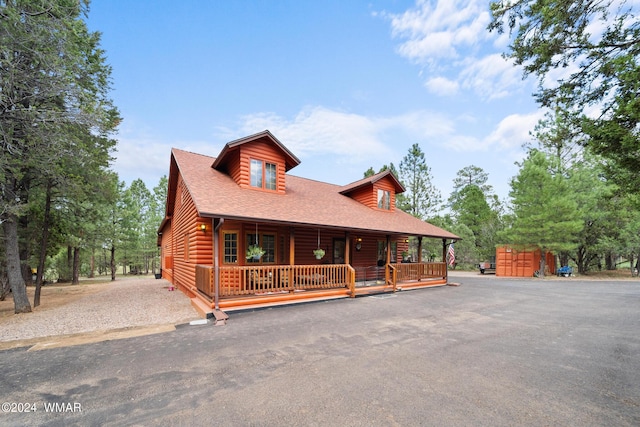 view of front of home with a porch, driveway, and a shingled roof