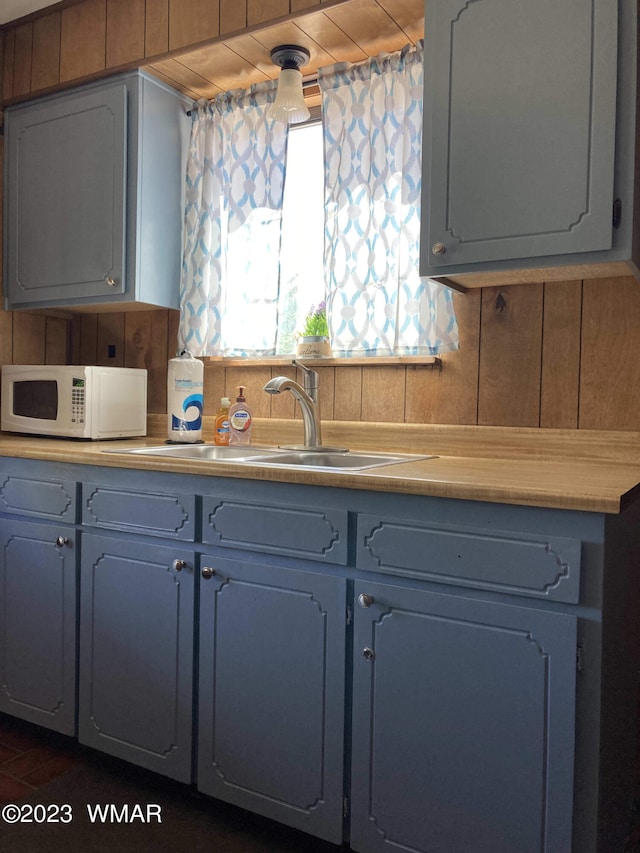 kitchen with white microwave, light countertops, and a sink