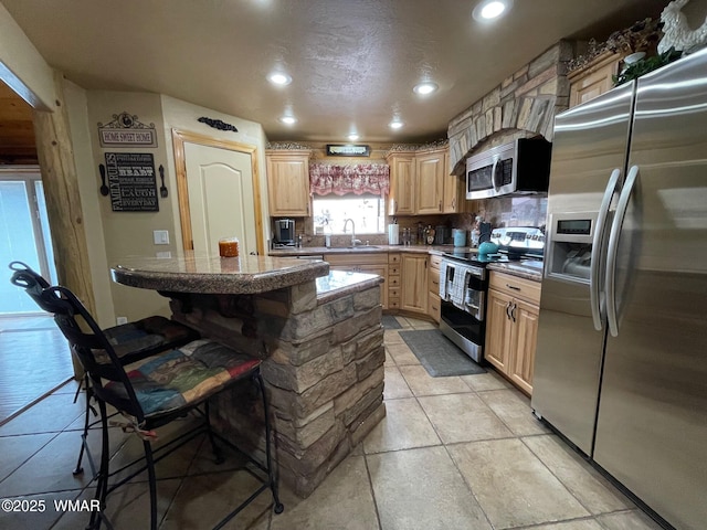 183 N Becker Lake Rd, Springerville, AZ 85938 - kitchen with stainless steel appliances, light brown cabinets, a breakfast bar area, recessed lighting, and a kitchen island