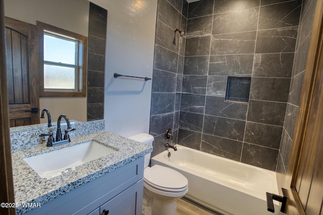 bathroom with washtub / shower combination, vanity, and toilet