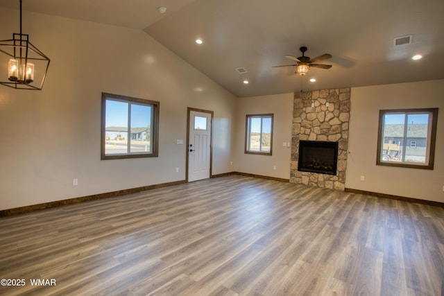 unfurnished living room with ceiling fan with notable chandelier, visible vents, baseboards, and wood finished floors