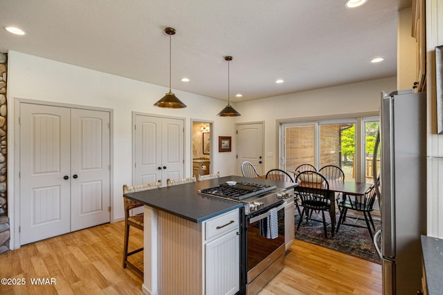 1415 N Lake View Cir, Lakeside, AZ 85929 - kitchen with stainless steel appliances, dark countertops, light wood finished floors, a kitchen breakfast bar, and recessed lighting