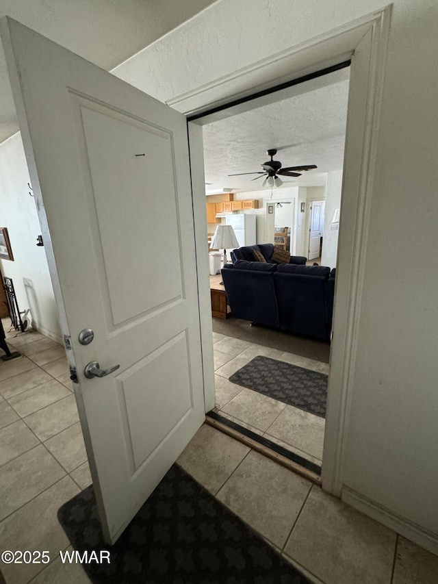 1259 Stallion Rd, Winslow, AZ 86047 - corridor featuring light tile patterned floors, baseboards, and a textured ceiling