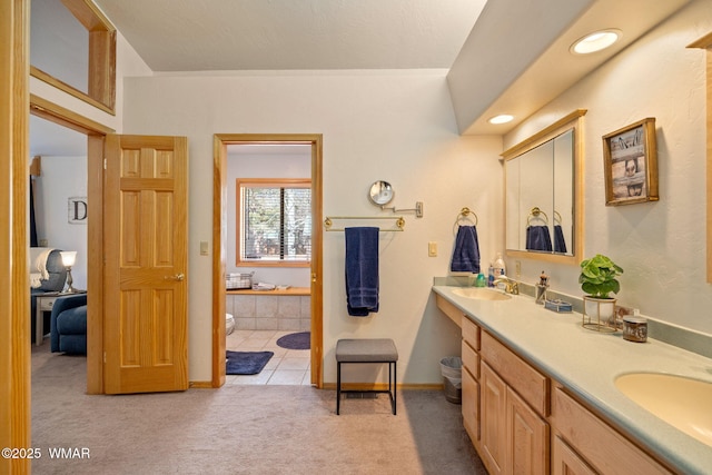 bathroom featuring a sink, baseboards, and double vanity