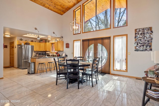 dining space with a notable chandelier, wood ceiling, and baseboards