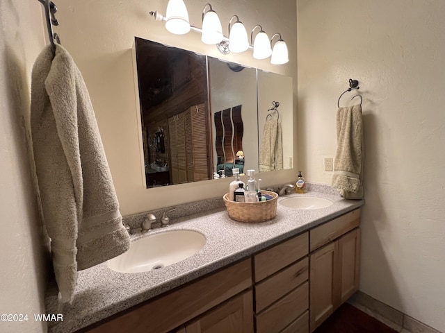 full bathroom with double vanity and a sink