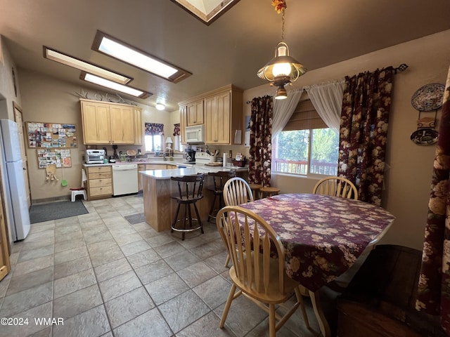 dining room with lofted ceiling with skylight