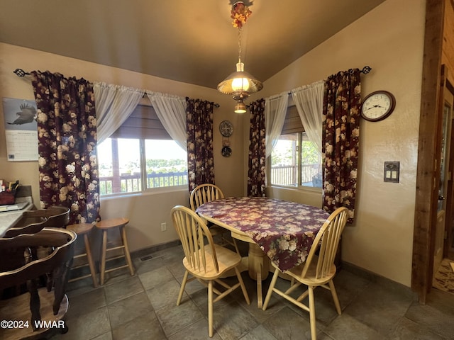 dining room with vaulted ceiling, tile patterned floors, visible vents, and baseboards