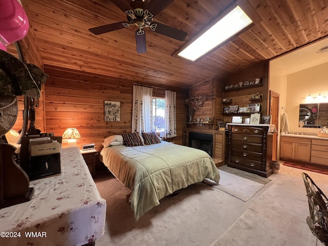 bedroom with light carpet, lofted ceiling, wood ceiling, ensuite bath, and wood walls