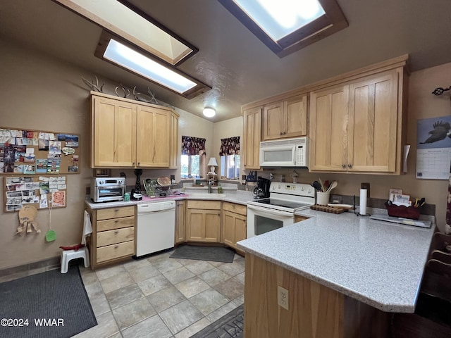 kitchen featuring white appliances, light countertops, a peninsula, and light brown cabinetry